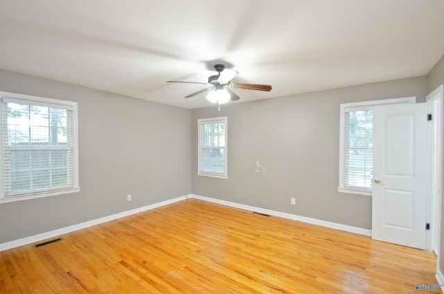 spare room with light hardwood / wood-style floors, a healthy amount of sunlight, and ceiling fan