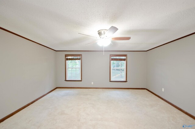 empty room featuring ornamental molding, ceiling fan, a textured ceiling, and light colored carpet