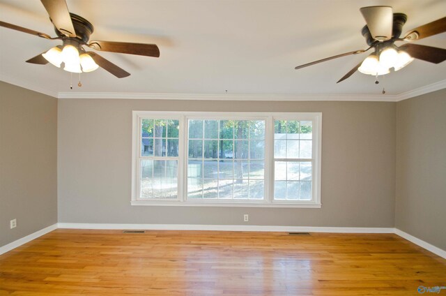 spare room featuring crown molding, light wood-type flooring, and ceiling fan