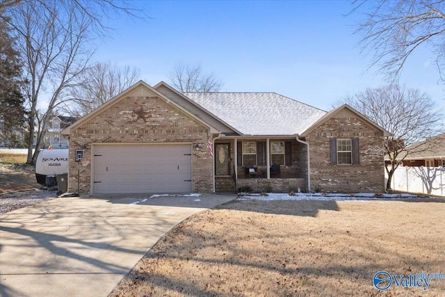 single story home featuring a garage, driveway, brick siding, and covered porch