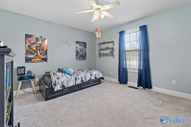 bedroom featuring light carpet, a ceiling fan, baseboards, and a textured ceiling