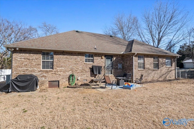 rear view of house with crawl space, brick siding, a patio, and roof with shingles