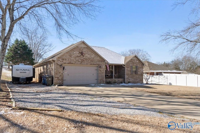 view of front facade featuring gravel driveway, brick siding, fence, and an attached garage