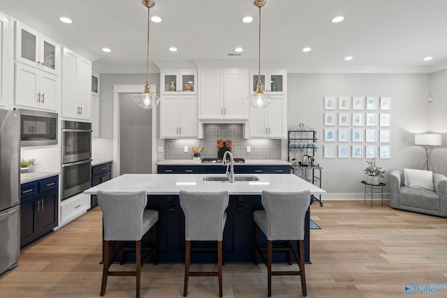 6320 Loring Loop NW, Huntsville, AL 35806 - kitchen featuring stainless steel appliances, blue cabinets, light countertops, white cabinetry, and tasteful backsplash