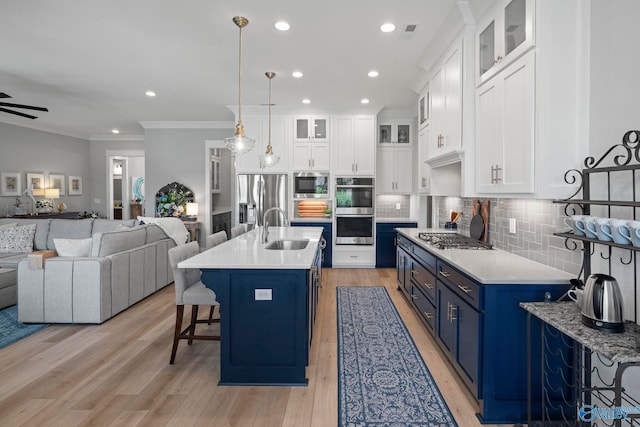 6320 Loring Loop NW, Huntsville, AL 35806 - kitchen featuring blue cabinetry, stainless steel appliances, open floor plan, a kitchen breakfast bar, and light wood-type flooring