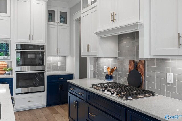 6320 Loring Loop NW, Huntsville, AL 35806 - kitchen featuring blue cabinets, stainless steel appliances, tasteful backsplash, and white cabinetry