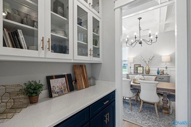 6320 Loring Loop NW, Huntsville, AL 35806 - bar featuring a chandelier, coffered ceiling, light wood-style floors, beamed ceiling, and decorative light fixtures