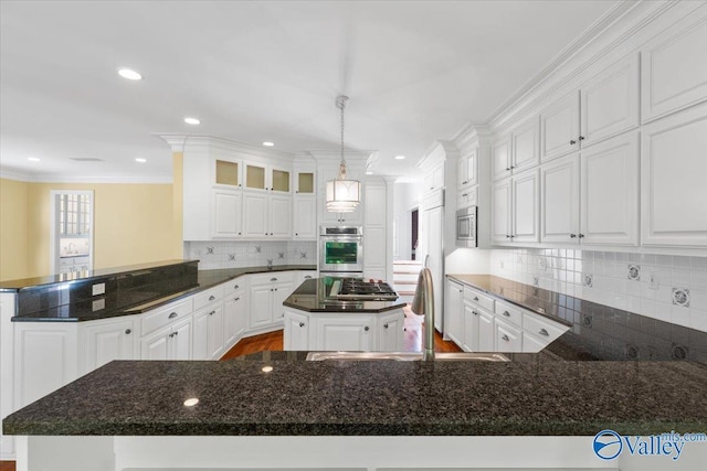 kitchen with white cabinetry, a center island, crown molding, and kitchen peninsula