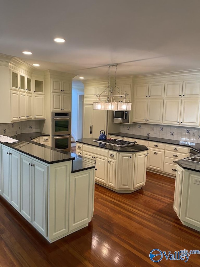 kitchen featuring pendant lighting, a center island, white cabinets, and appliances with stainless steel finishes