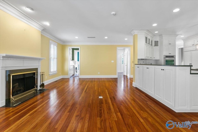 unfurnished living room with dark hardwood / wood-style flooring and ornamental molding