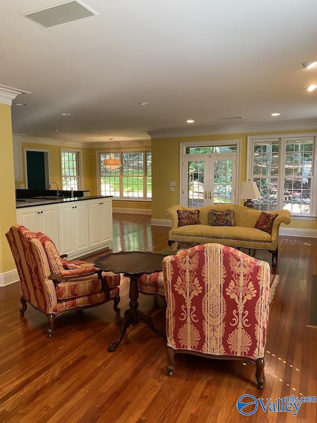 living room featuring french doors, plenty of natural light, dark hardwood / wood-style flooring, and crown molding