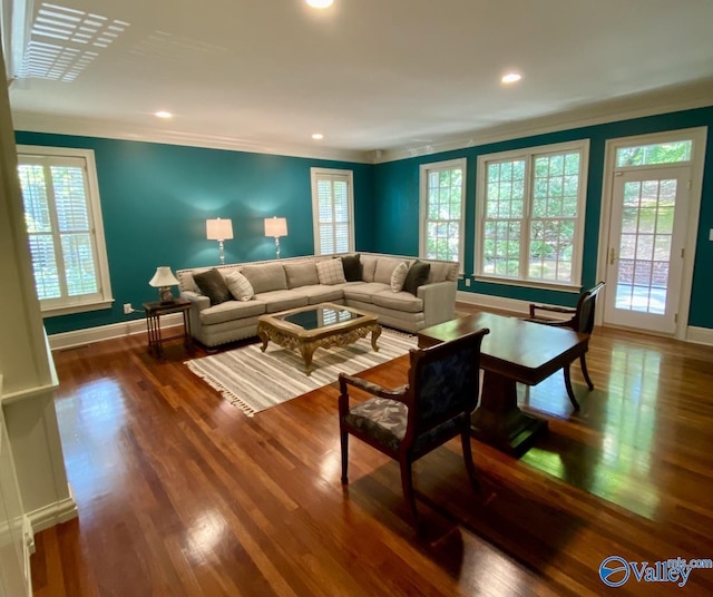 living room featuring ornamental molding, a healthy amount of sunlight, and dark wood-type flooring