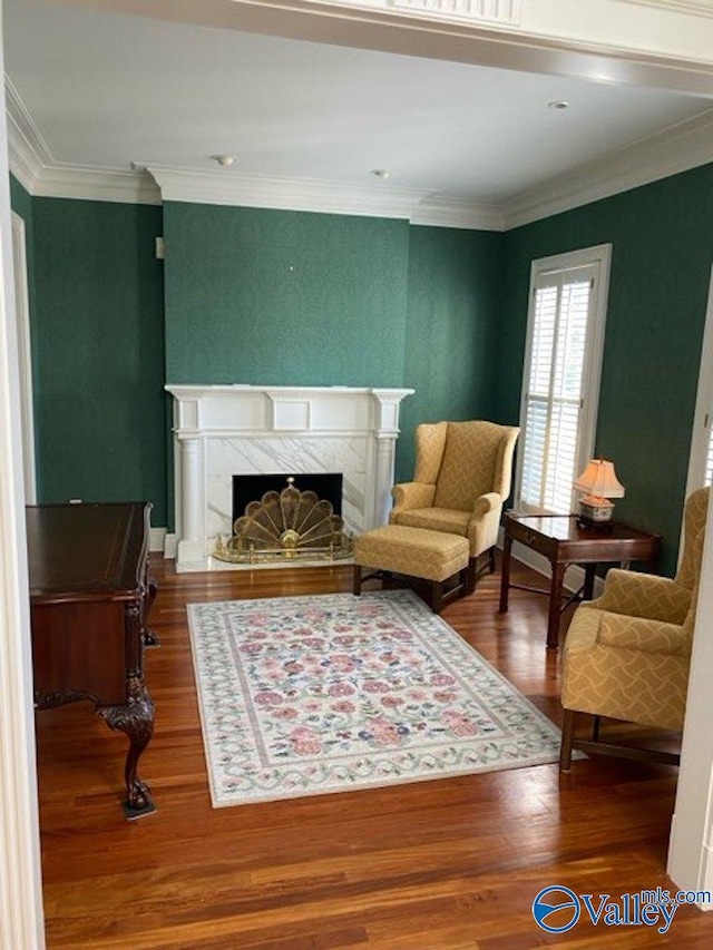 living area featuring crown molding, hardwood / wood-style flooring, and a premium fireplace