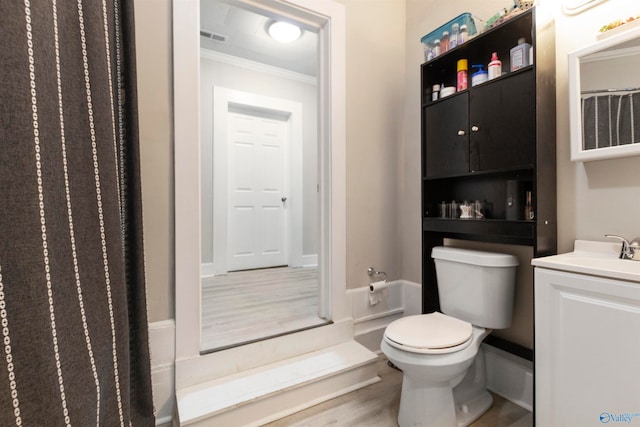 bathroom featuring crown molding, hardwood / wood-style floors, toilet, vanity, and a shower with shower curtain