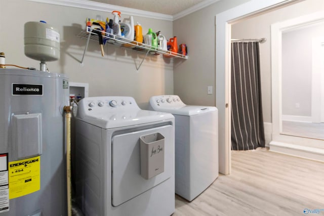 laundry area featuring washing machine and clothes dryer, electric water heater, light hardwood / wood-style flooring, crown molding, and a textured ceiling