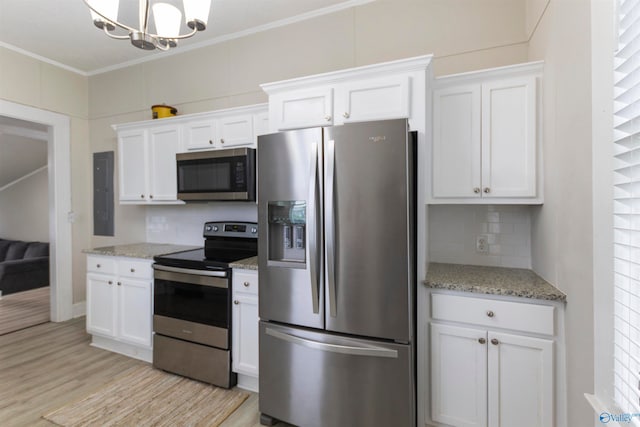 kitchen with white cabinets, crown molding, and stainless steel appliances