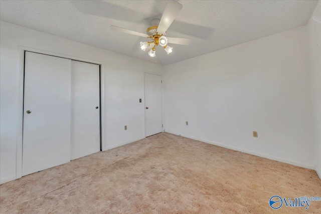 unfurnished bedroom with a ceiling fan, carpet, a closet, and a textured ceiling