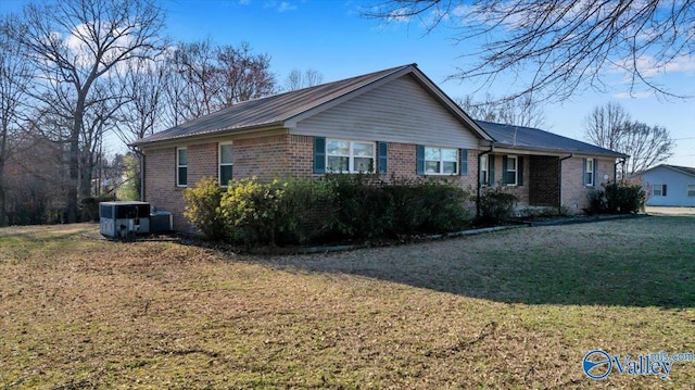 view of property exterior with brick siding and a lawn