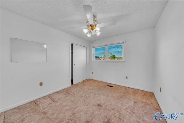 unfurnished bedroom with visible vents, a textured ceiling, a closet, carpet flooring, and baseboards