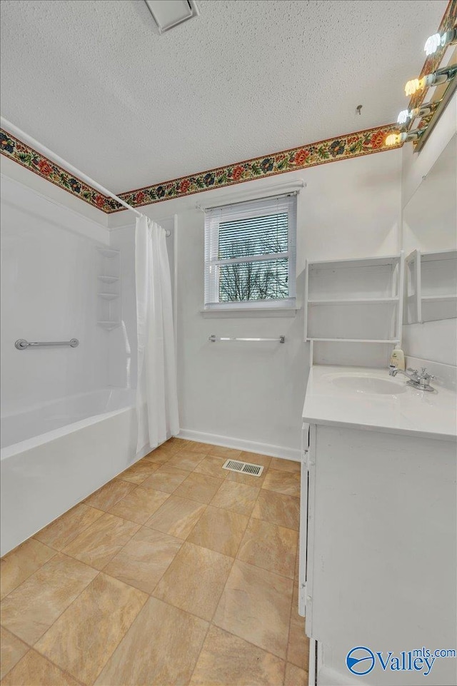 bathroom featuring visible vents, a textured ceiling, vanity, and baseboards