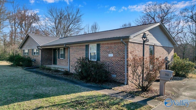 view of front facade with a front lawn, brick siding, and metal roof