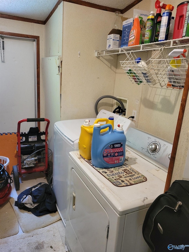 laundry area with ornamental molding, washer and clothes dryer, and a textured ceiling