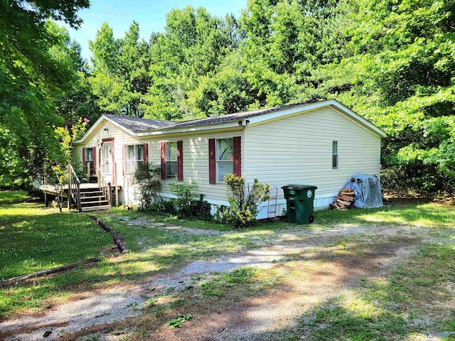 view of front of property featuring a deck and a front lawn