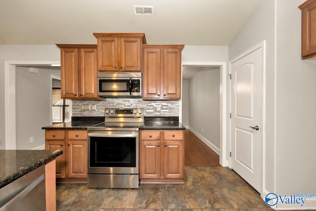 kitchen with backsplash, dark stone countertops, and appliances with stainless steel finishes