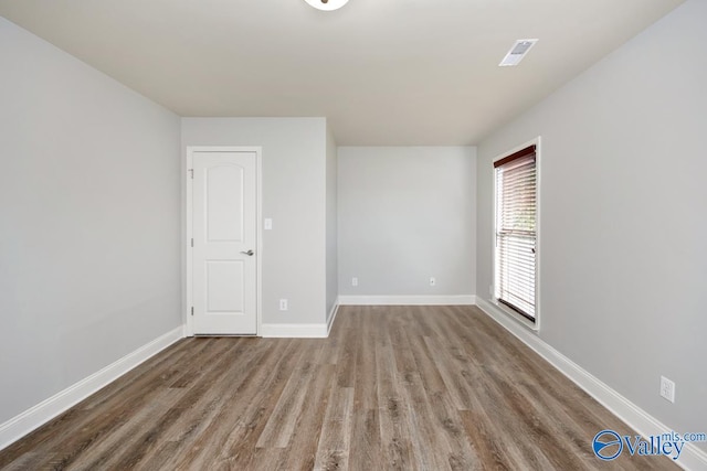 unfurnished room with wood-type flooring