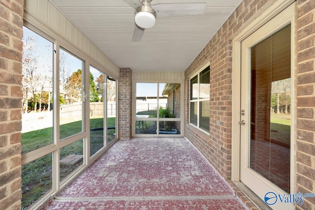 unfurnished sunroom with ceiling fan