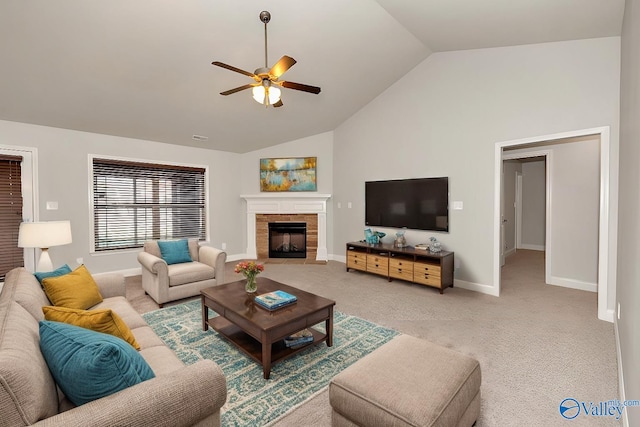 living room with ceiling fan, light carpet, high vaulted ceiling, and a tiled fireplace