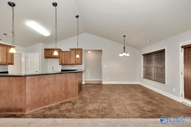 kitchen with backsplash, dark stone countertops, a chandelier, hanging light fixtures, and lofted ceiling