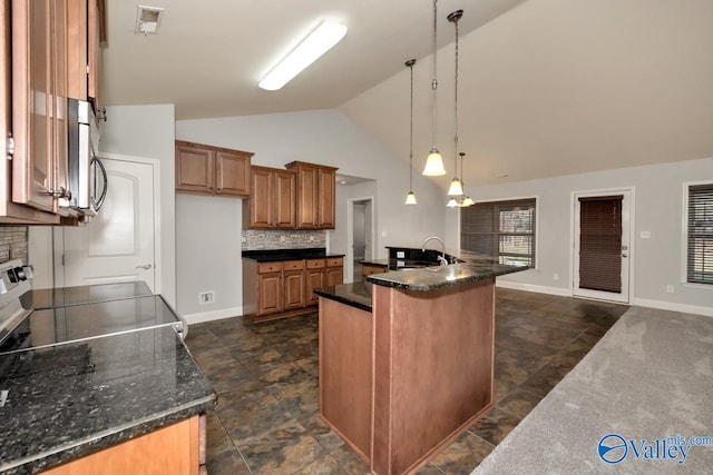 kitchen featuring decorative backsplash, a kitchen island with sink, decorative light fixtures, high vaulted ceiling, and range