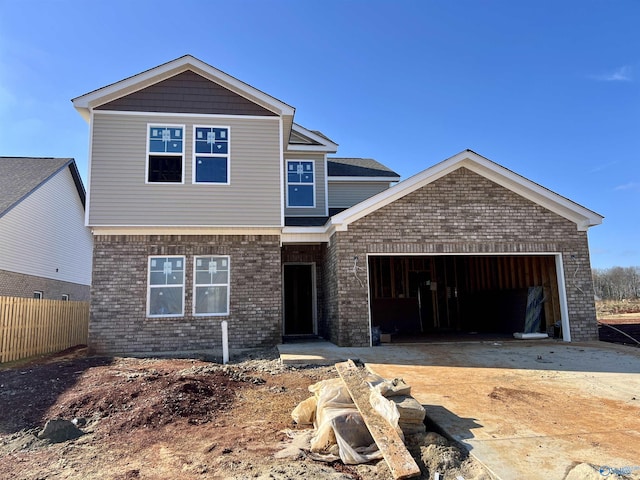 view of front of property with an attached garage, driveway, fence, and brick siding