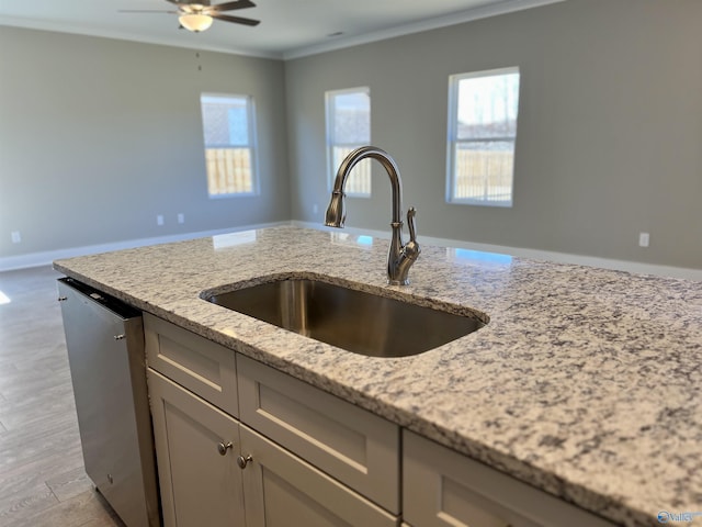 kitchen featuring a sink, a wealth of natural light, ornamental molding, and stainless steel dishwasher