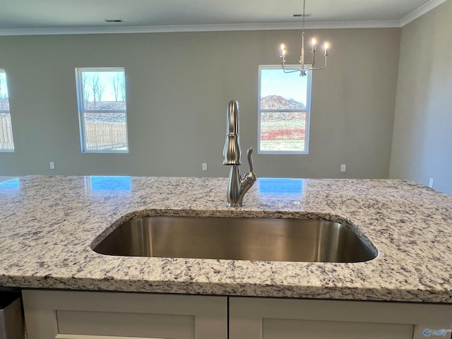 kitchen featuring a wealth of natural light, a sink, visible vents, and light stone countertops