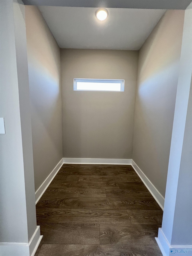 empty room featuring baseboards and dark wood finished floors