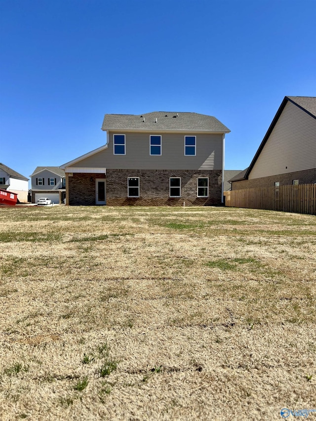 back of house featuring a lawn and fence