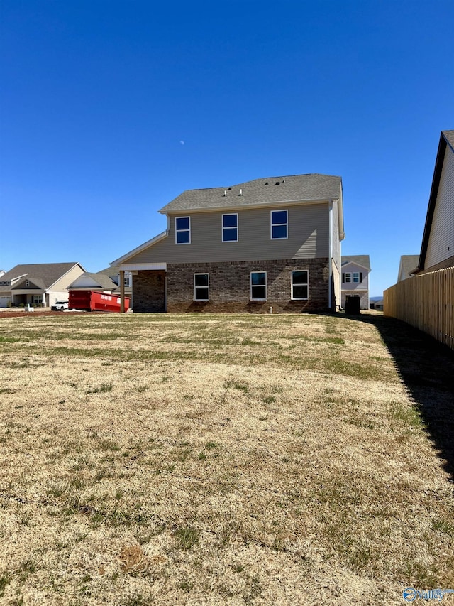 rear view of property with a yard and fence