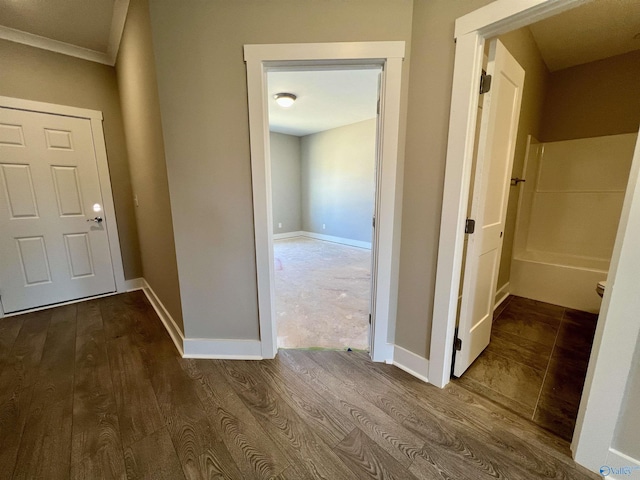 hallway with dark wood finished floors and baseboards