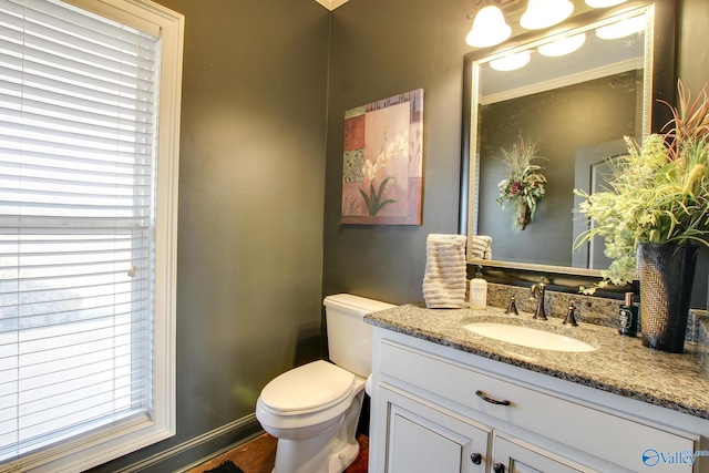 bathroom featuring a healthy amount of sunlight, vanity, and toilet