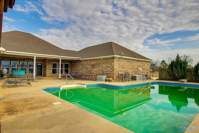 view of pool with central AC, a patio area, and a diving board