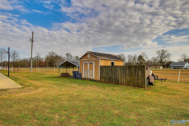 view of yard featuring a carport and a storage unit