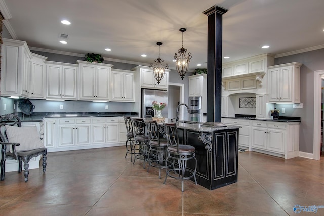 kitchen featuring a kitchen bar, crown molding, decorative light fixtures, appliances with stainless steel finishes, and a kitchen island with sink