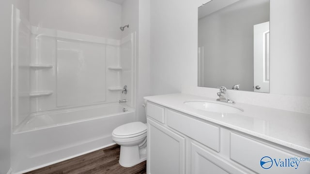 full bathroom featuring hardwood / wood-style floors, vanity, toilet, and shower / tub combination