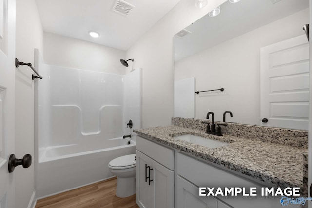 bathroom featuring wood finished floors, shower / bathing tub combination, vanity, toilet, and visible vents