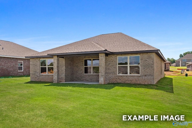 rear view of property with brick siding, a lawn, a patio, and roof with shingles