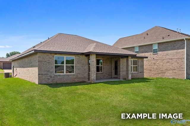 back of house with central AC, brick siding, and a yard