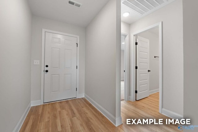 doorway to outside featuring visible vents, light wood finished floors, and baseboards