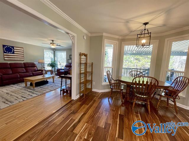 dining space featuring ornamental molding, baseboards, a ceiling fan, and wood finished floors